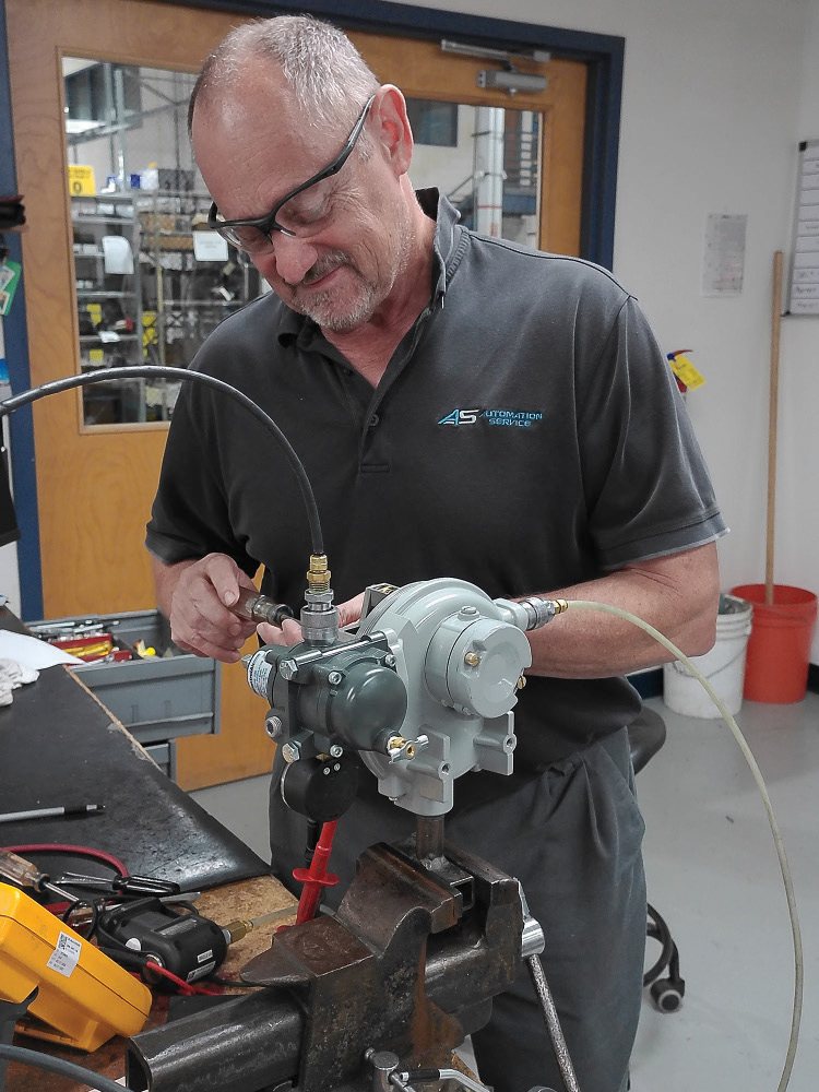 An Automation Service technician rebuilding a control valve assembly at the bench